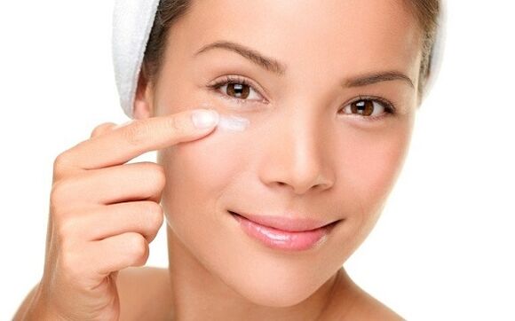 Applying cream to rejuvenate the skin around the eyes